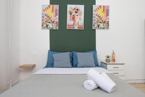 een slaapkamer met een bed met drie foto's aan de muur bij Godson down town in Haifa