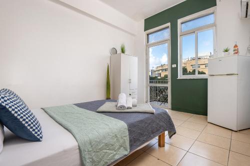 a bedroom with a bed and a large window at Godson down town in Haifa