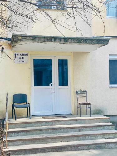 a house with a door and a chair on the porch at Suite4Rent Iași in Iaşi