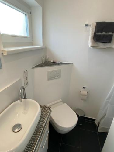 a bathroom with a white toilet and a sink at Häuschen mit Gartenblick in Idstein
