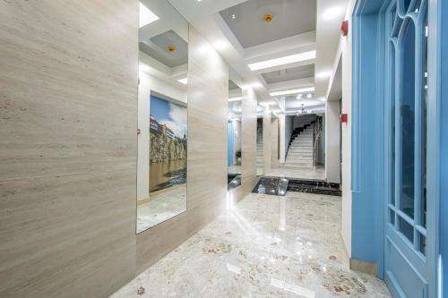 a hallway with a blue door and marble floors at Metekhi Boutique Hotel in Tbilisi City