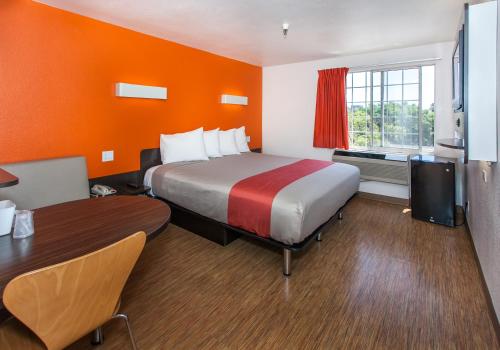 a hotel room with a large bed and a table at Motel 6 Hollywood in Los Angeles