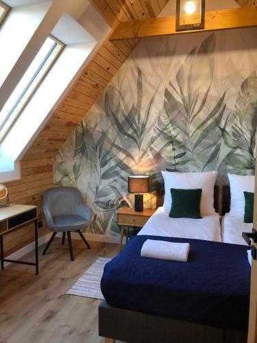 a bedroom with a king sized bed with a painting on the wall at Bystre DOMKI in Nowe Bystre