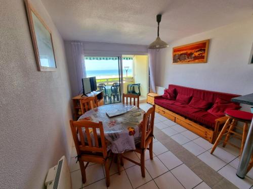 un salon avec un canapé rouge et une table dans l'établissement Plage océan, à Mimizan