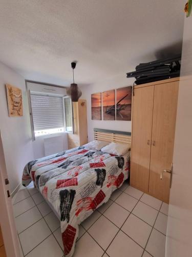 une chambre avec un lit avec une couette dessus dans l'établissement Plage océan, à Mimizan