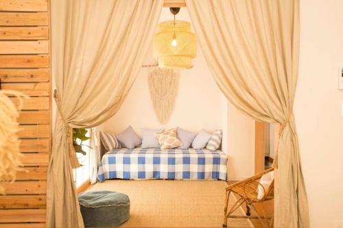 a bedroom with a bed with a blue and white blanket at ライカムまで10分!!大人女子にオススメ。フォトジェニックなアンティーク家具に囲まれて最高の夜を。。 in Awase