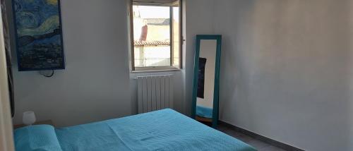 una camera con letto blu e specchio di L'Isoletta a Rignano Flaminio