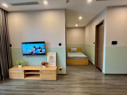 a room with a bed and a tv on a wall at Bunny Bliss-Service Apartment in Hanoi