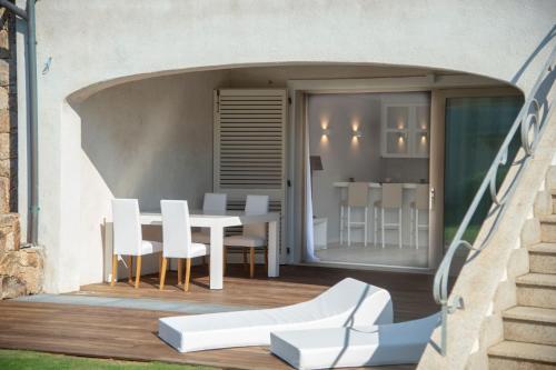 a patio with a white table and chairs on a balcony at La Sciumara Resort Palau in Palau
