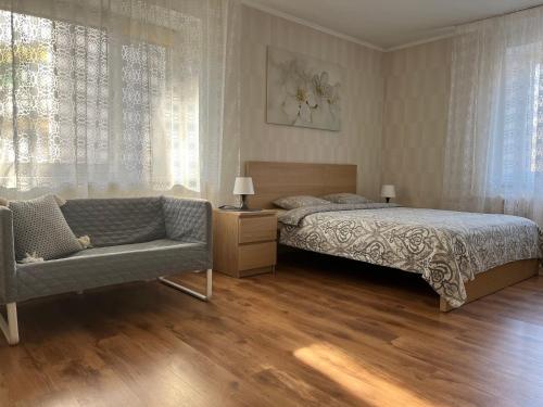 a bedroom with a bed and a couch at Imantas apartment in Daugavpils