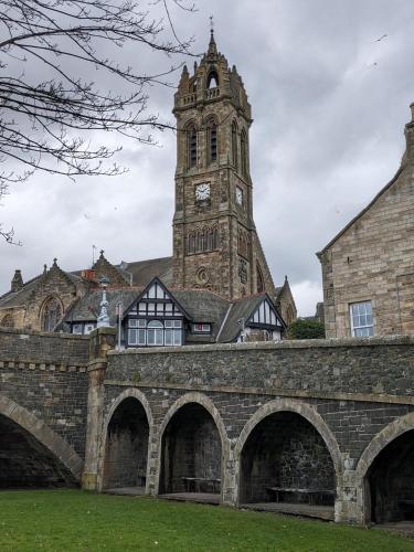 an old building with a clock tower in the background at Peaceful Getaway In Peebles in Peebles