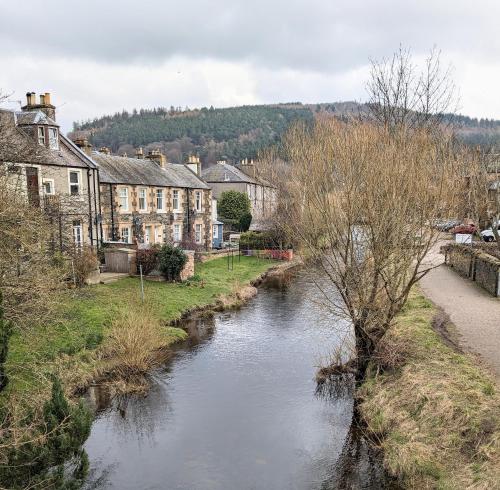 a river in a small town with houses and buildings at Peaceful Getaway In Peebles in Peebles