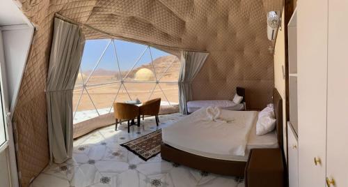 Pokój z łóżkiem i dużym oknem w obiekcie Rum Aranda camp & Jeep Tour w mieście Wadi Rum