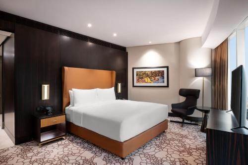 a bedroom with a bed and a desk and a chair at Hilton Riyadh Olaya in Riyadh