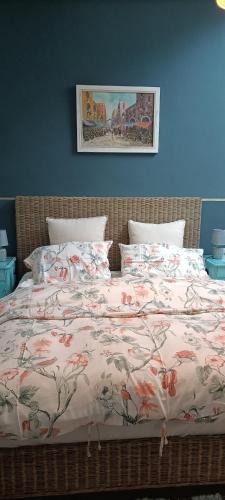 a bed with a floral comforter and pillows at Casale Il Girasole in San Costanzo