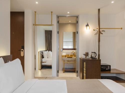 um quarto com uma cama, uma secretária e uma cadeira em Nidhra Boutique em Bangkok