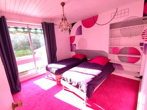 ein Schlafzimmer mit 2 Betten und ein rosafarbenes Zimmer in der Unterkunft Gite LE 45 TOURS in Nueil-sous-les-Aubiers