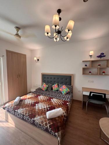 een slaapkamer met een groot bed en een kroonluchter bij Crystal box NIMBUS Noida expressway in Noida