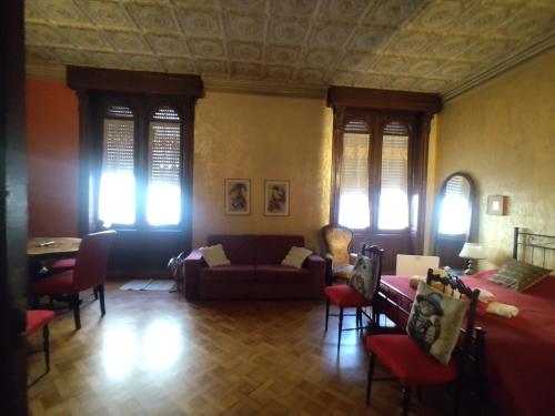 salon z kanapą, stołami i oknami w obiekcie B&B Amarantha Gothica Genoa w Genui