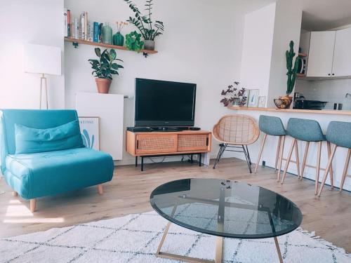 uma sala de estar com um sofá azul e uma mesa de vidro em JO 2024 proche Stade France et Paris Ligne 14, 13 em Saint-Ouen