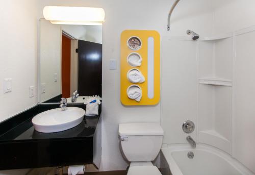 a bathroom with a toilet and a sink and a mirror at Motel 6 Hollywood in Los Angeles