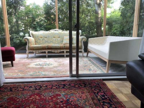 a living room with a couch and a window at Kashiwanoha Hotspring Garden Villa&Suite Room in Kashiwa