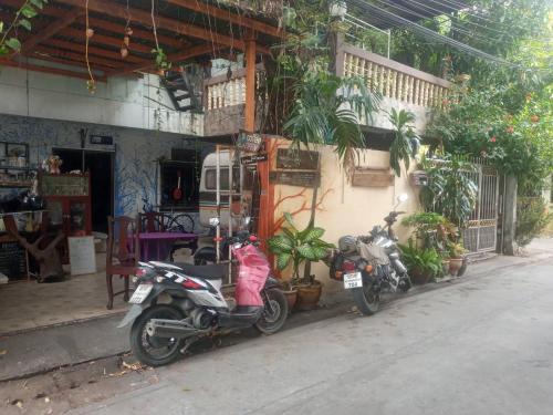 dos motocicletas estacionadas frente a un edificio en GN GOOD NICE en Bangkok