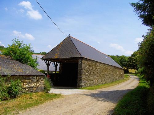 a stone barn with a black roof on a dirt road at Caurelgranges in Caurel