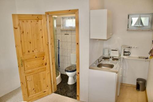 a small kitchen with a sink and a toilet at schöner Gartenbungalow (Nr. 2) mit Terrasse - Strandvogtei Sellin in Ostseebad Sellin