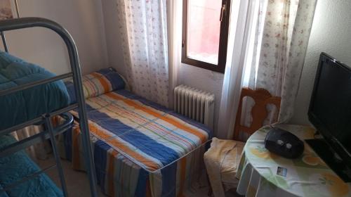 a small bedroom with a bunk bed and a table at Habitacion Privada Triple Toledo in Toledo
