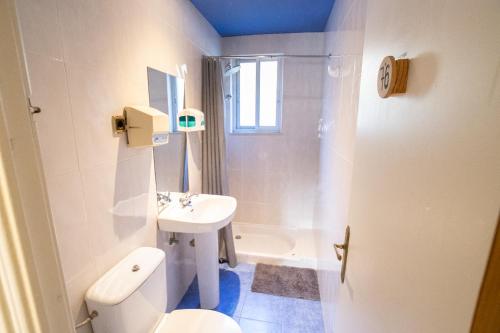 a bathroom with a white toilet and a sink at Carving Surf Hostel in San Esteban de Pravia