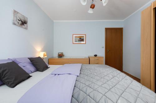 1 dormitorio con 1 cama blanca grande con almohadas moradas en Apartment Stay By Me, en Split