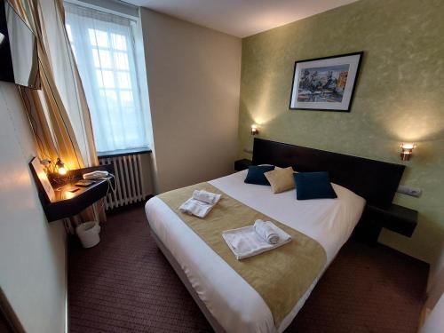een hotelkamer met een bed met handdoeken erop bij Logis Hôtels - Hôtel et Restaurant Le Lion d'Or in Gramat