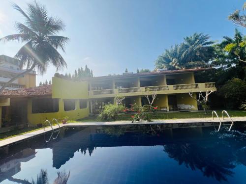 a house with a swimming pool in front of it at Muthumuni Ayurveda River Resort in Aluthgama