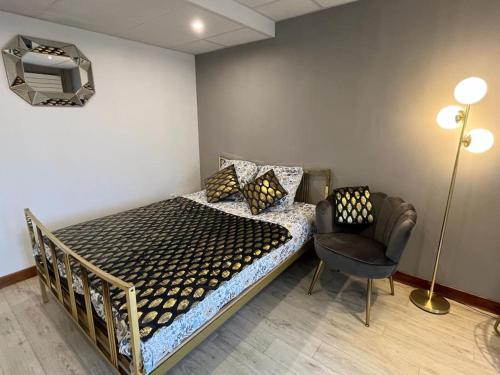 a bed in a room with a chair and a lamp at Golden Tours - Studio moderne in Tours