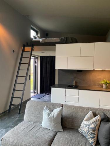a living room with a couch and a loft bed at Minihus i Tygelsjö in Tygelsjö