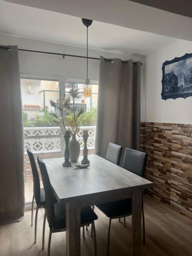 een eetkamer met een houten tafel en stoelen bij Casa Pom at the Beach in Torre de Benagalbón