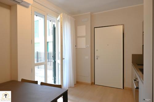 a dining room with a table and a large window at Inn Pisa Rentals - Pisa Tower Flat in Pisa