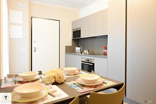 een keuken met een tafel met borden erop bij Inn Pisa Rentals - Pisa Tower Flat in Pisa