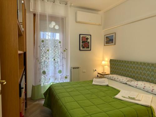 Cama verde en habitación con ventana en Dario's House en Scandicci
