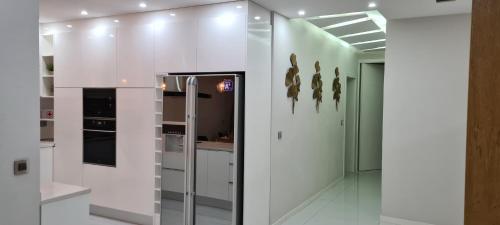 uma cozinha com paredes brancas e utensílios de aço inoxidável em Cazinos Apartamento 2 em Praia