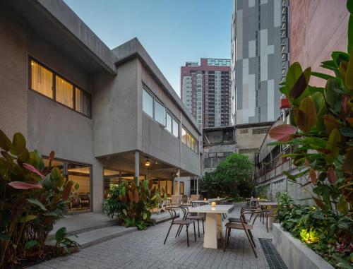 a patio with tables and chairs in a building at Nidhra Boutique Hotel Bangkok Sukhumvit in Bangkok