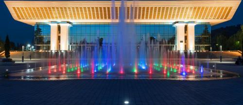 un grand bâtiment avec une fontaine devant lui dans l'établissement Nadezhda Apartment on Abay Avenue 59, à Almaty