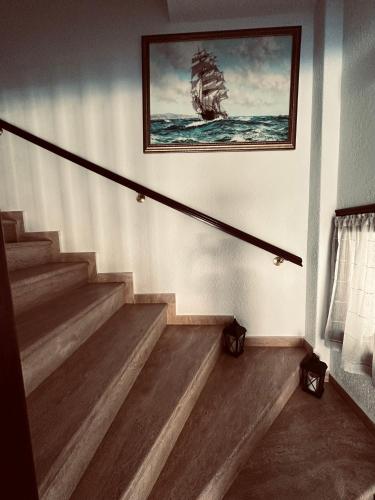 a staircase with a picture of a ship on the wall at Hotel Filoxenia in Ouranoupoli