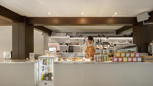 a woman standing behind a counter in a kitchen at Nidhra Boutique Hotel Bangkok Sukhumvit in Bangkok