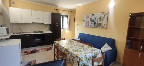 a kitchen with a blue couch and a table in a room at Complesso turistico Aurora - Appartamenti in Poggio Picenze