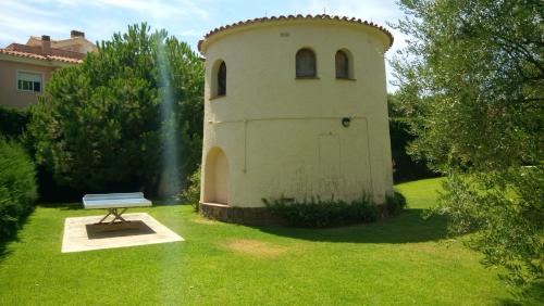 a building with a bench in the grass at VIDABRAVA, Sagaro garden loft in S'Agaro