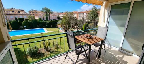 a balcony with a table and a view of a pool at VIDABRAVA, Sagaro garden loft in S'Agaro