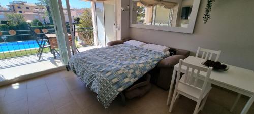a bedroom with a bed and a table and a balcony at VIDA BRAVA, S´agaro garden loft in S'Agaro