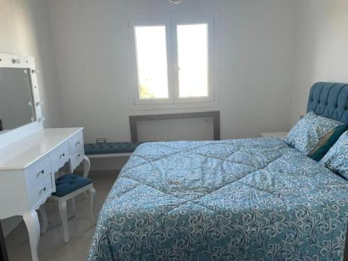 a bedroom with a bed and a dresser and a mirror at Résidence Tilel 2 à Chatt Mariem in Sousse